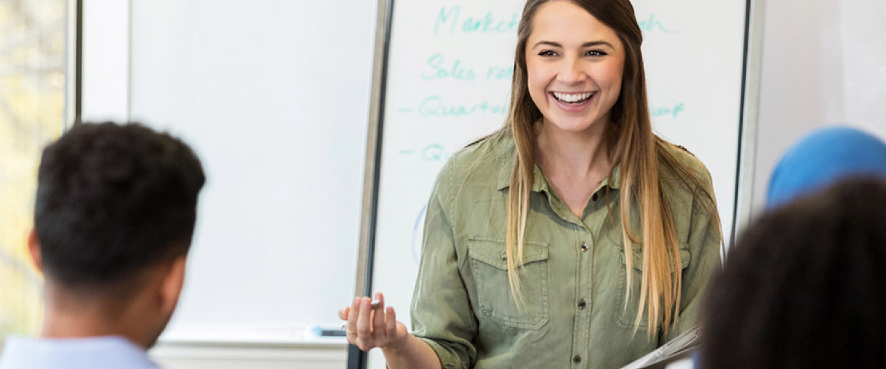 Young female teacher smiles and talks to her class